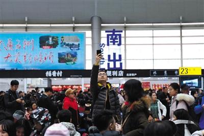 北京南站，一位男士在候车厅拍照