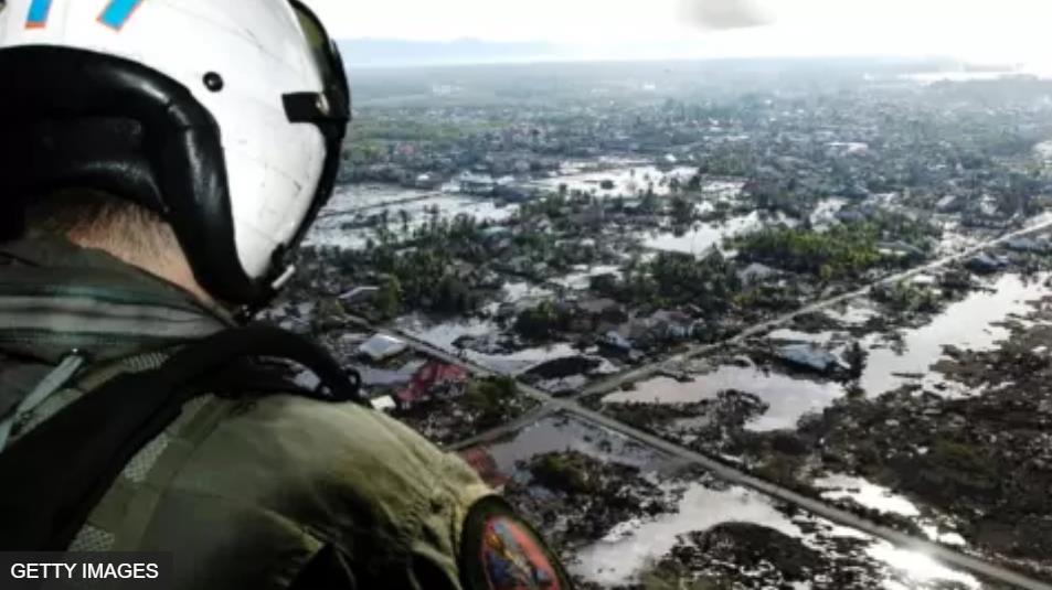 一架美国海军直升机飞过印尼苏门答腊灾区