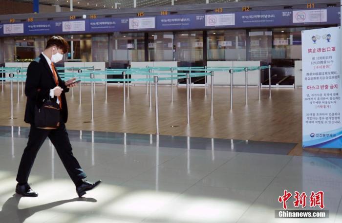 韩国仁川国际机场，工作人员走过机场大厅